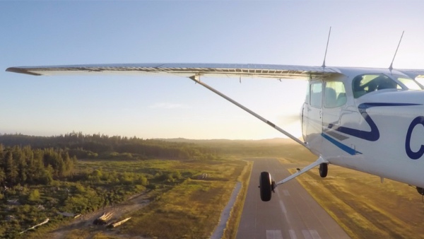 Small airplane taking off during bright sunny sunset. British Columbia, Canada.